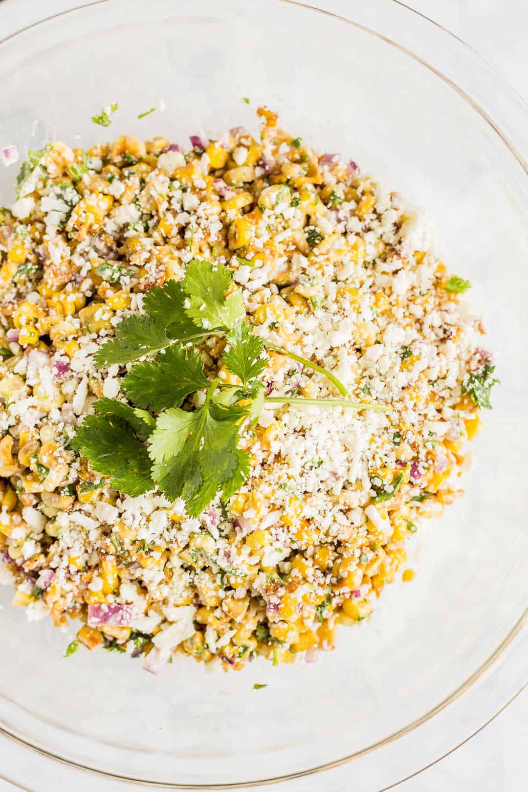 Mexican street corn in a clear bowl.