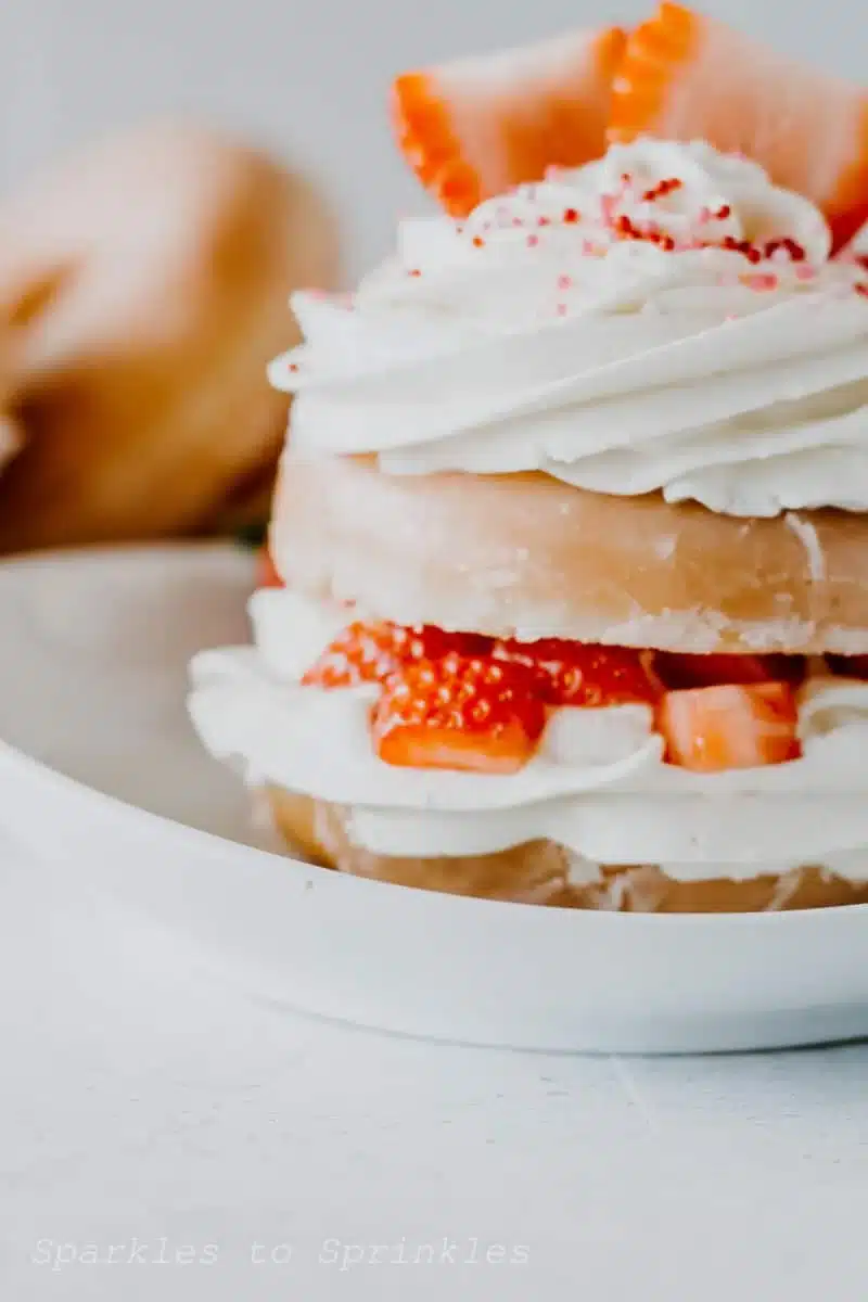 Strawberry cheesecake donut on a white plate.