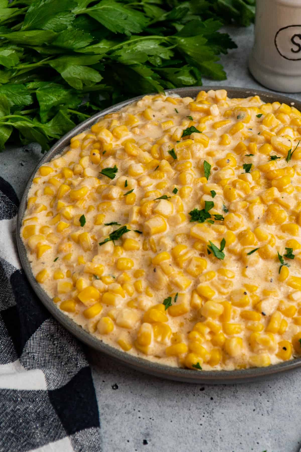 Slow cooker creamed corn on a gray plate.