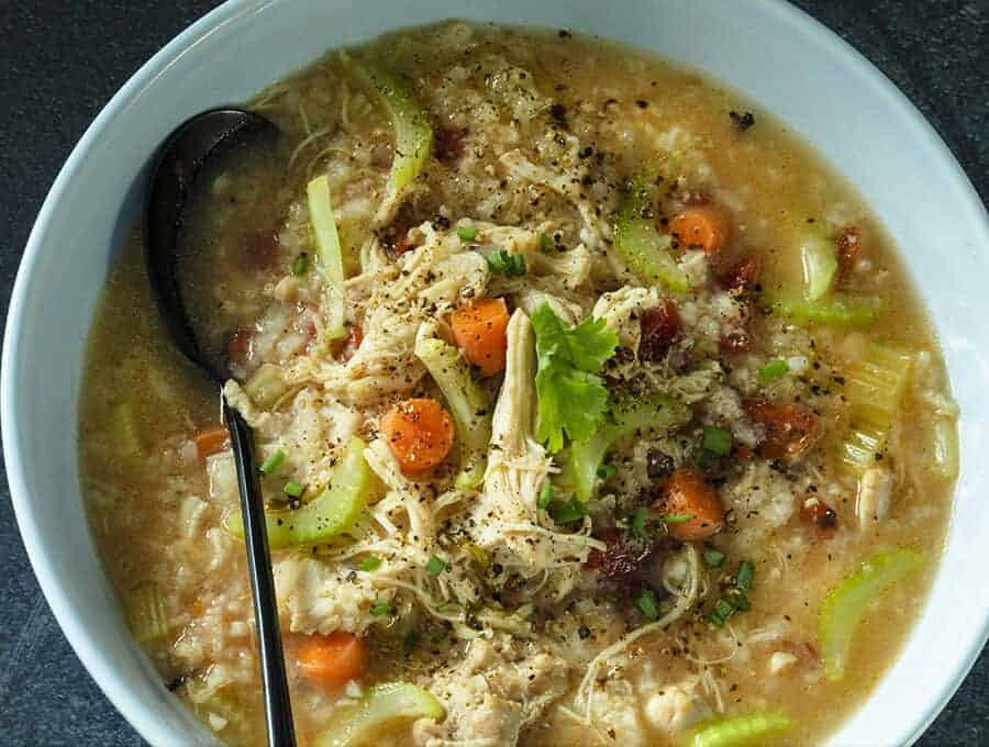 Mexican chicken soup in white bowl with spoon.