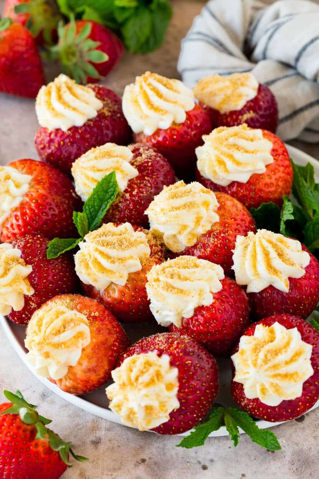 Cheesecake stuffed strawberries on a plate.