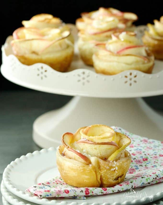 Apple rose puffs on a cake stand.