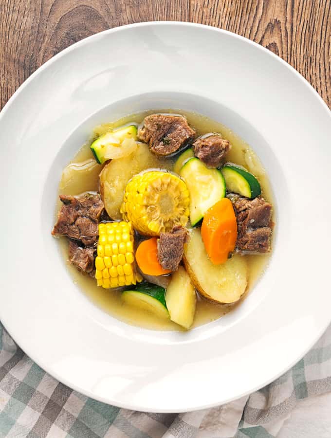 Caldo de res in a white bowl.