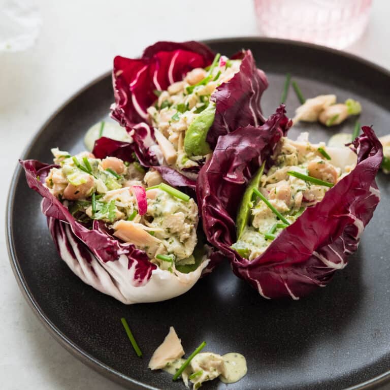 Tuna salad in sturdy radicchio leaves on a gray plate.