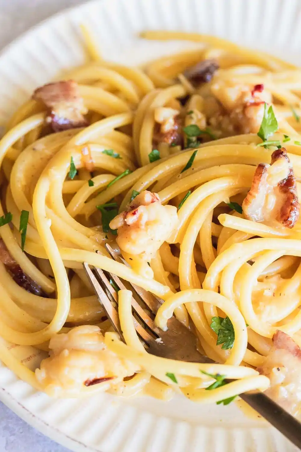 Pasta with lobster cream sauce on a plate with a fork.