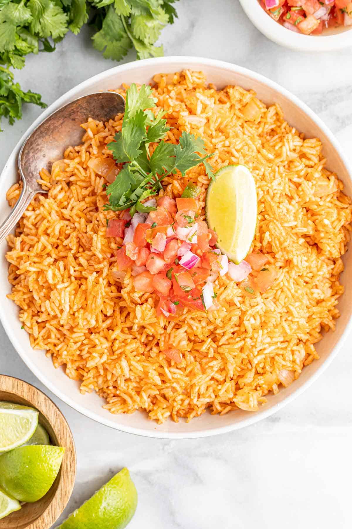 Instant Pot Spanish rice with salsa and lime wedge in a bowl.