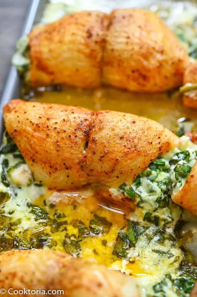 Creamy spinach stuffed flounder on a baking pan.