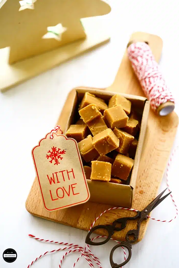 Cardamom and cinnamon caramels in a gift box with decorative twine, label, and scissors.