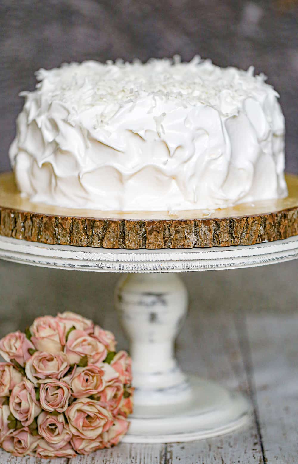 Coconut cake with marshmallow frosting on a cake stand.