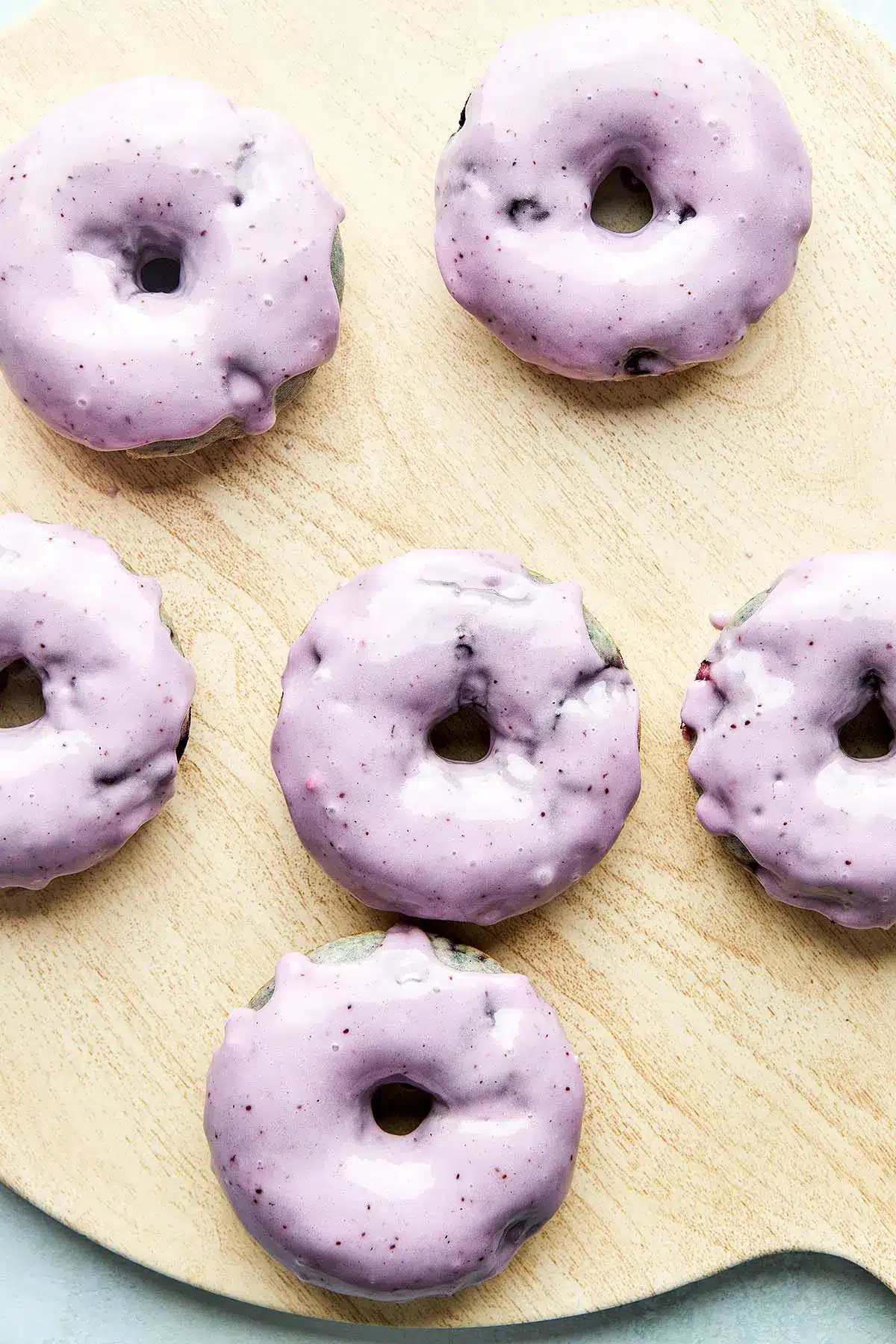 Blueberry cake donuts on a wooden platter.