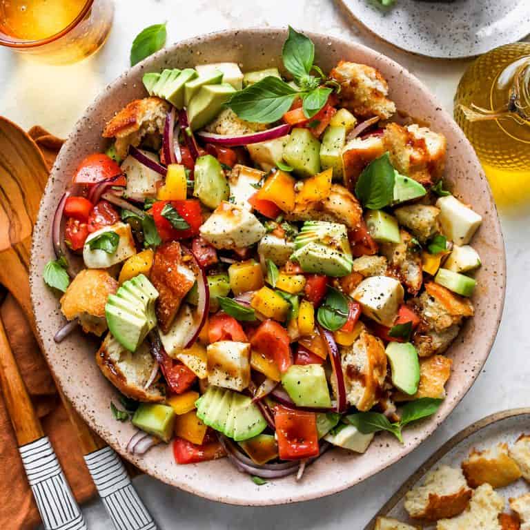 Panzanella salad in a bowl with serving spoons.