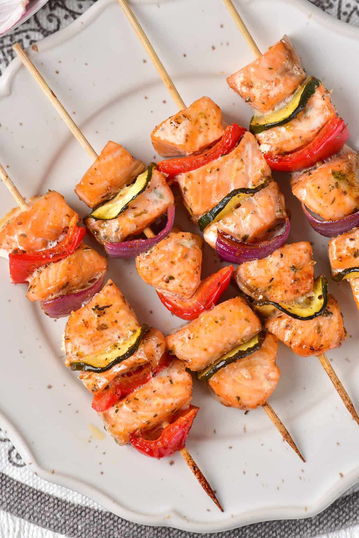 Salmon skewers on a white plate.