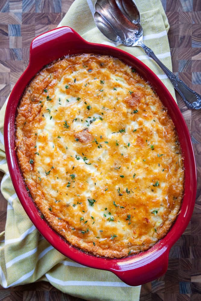 Savory corn pudding in a red baking dish.