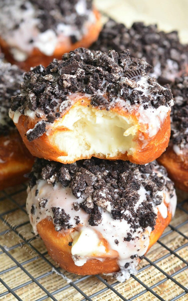 Oreo cheesecake doughnuts on a cooling rack.