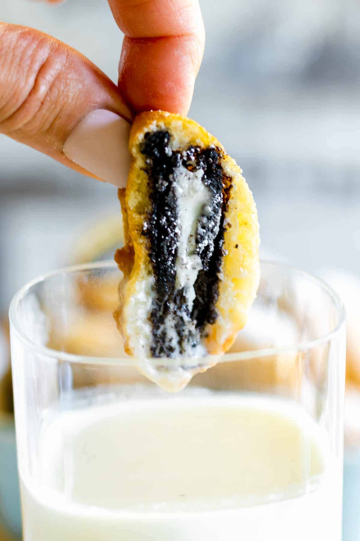 Hand holding deep fried Oreo.