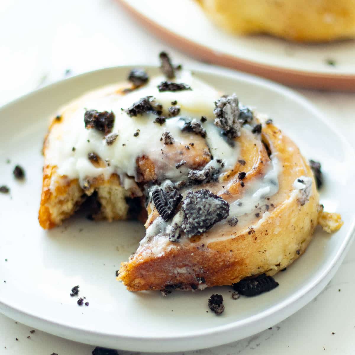 Oreo cinnamon roll on a saucer.