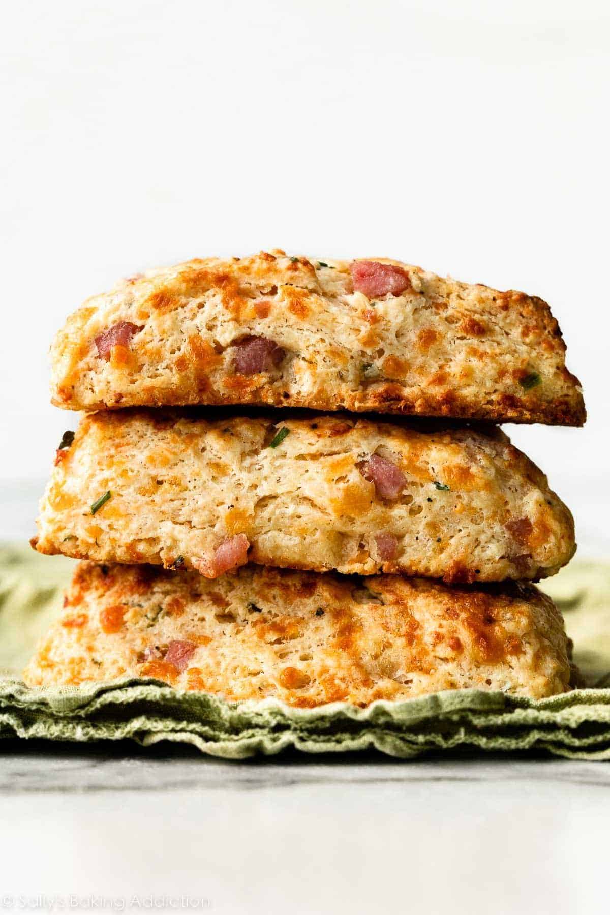 Stack of ham and cheese scones on a green dish cloth.