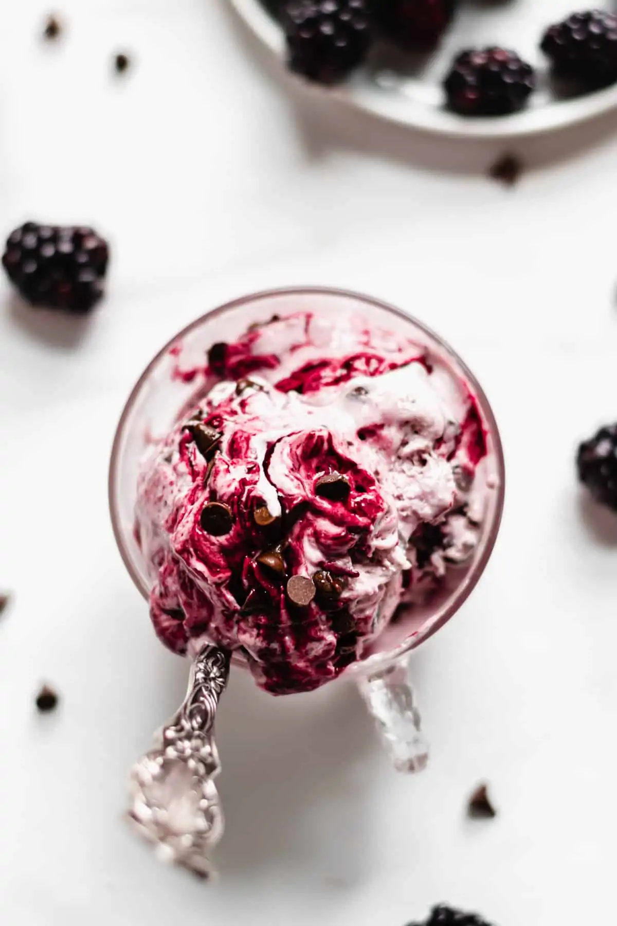 Blackberry ice cream with chocolate chips in a glass.