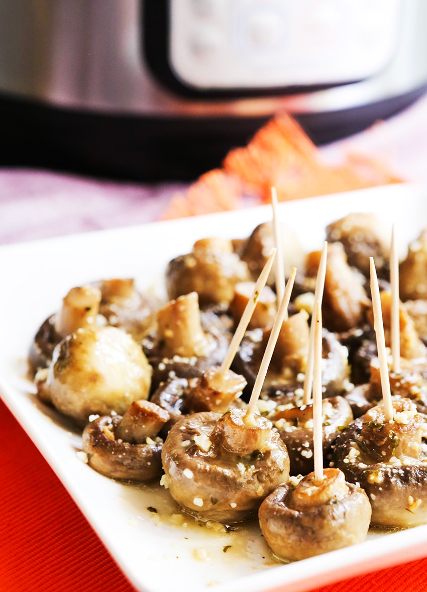 Instant pot mushrooms with butter ranch sauce with toothpicks on a square white plate.