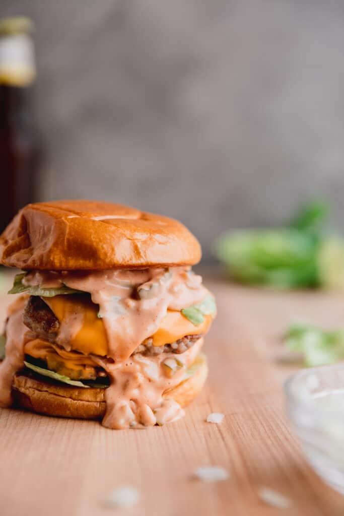 The ultimate pork burger on a wooden cutting board.