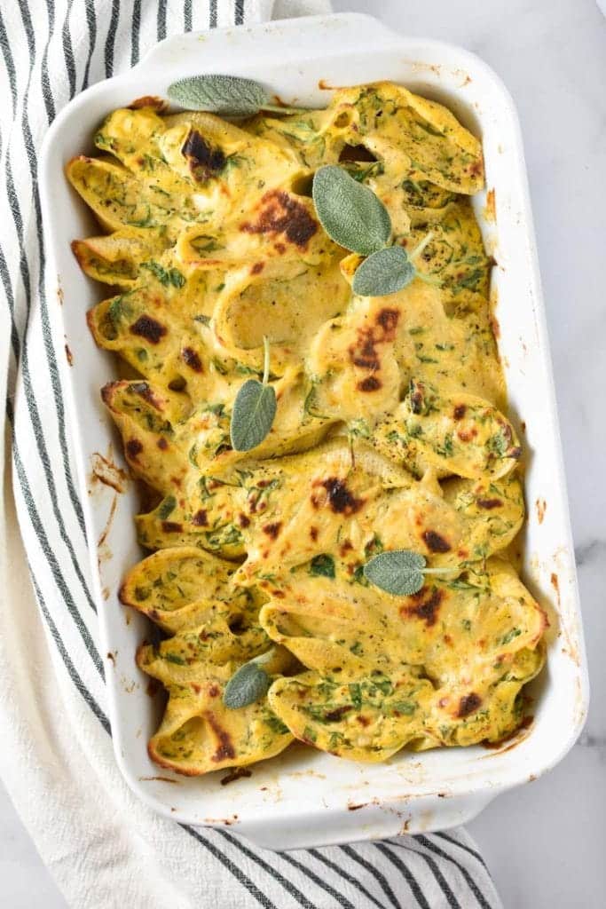 Butternut squash stuffed shells in a white baking dish.