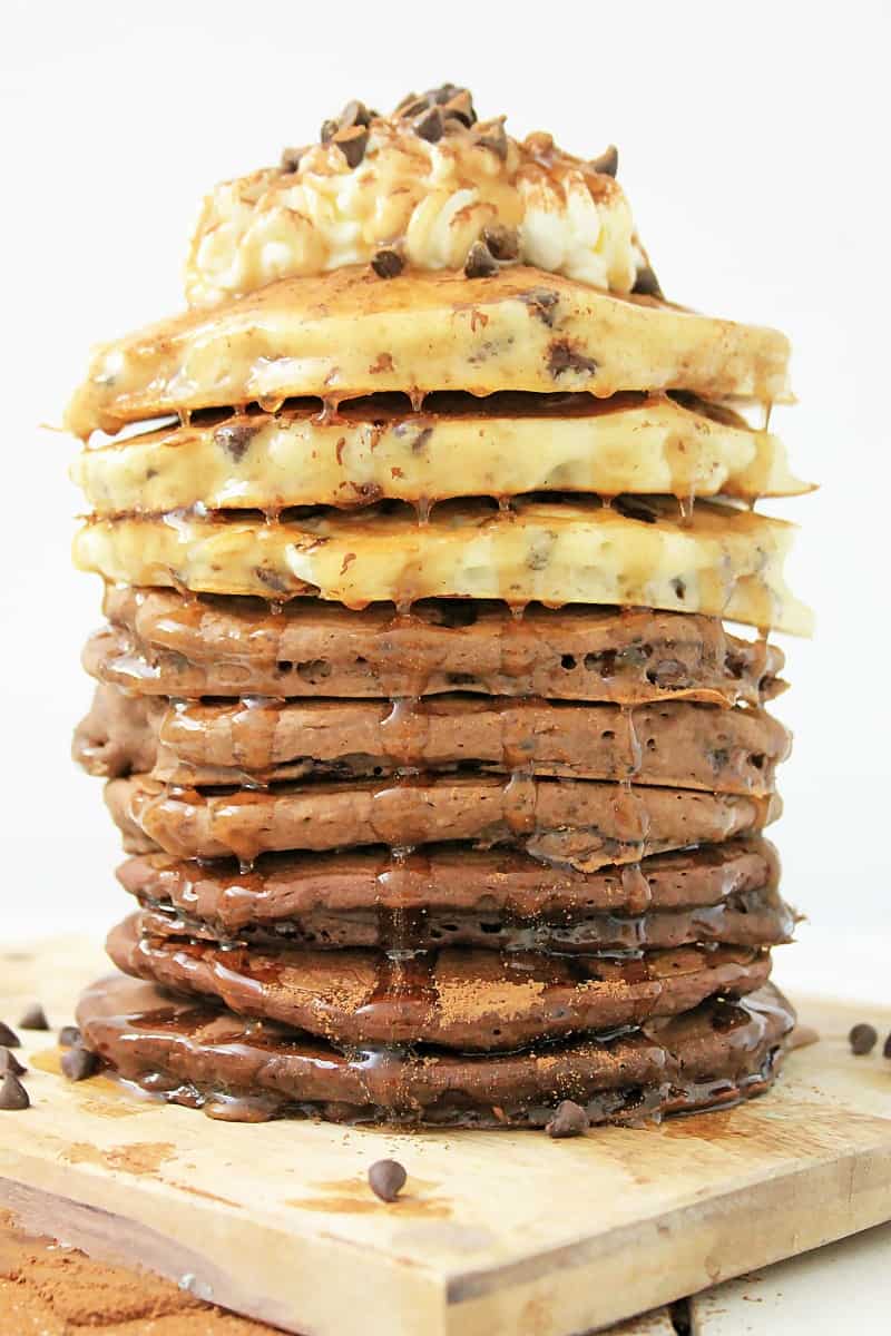 Stack of ombre chocolate chip pancakes with whipped cream and mini chocolate chips.