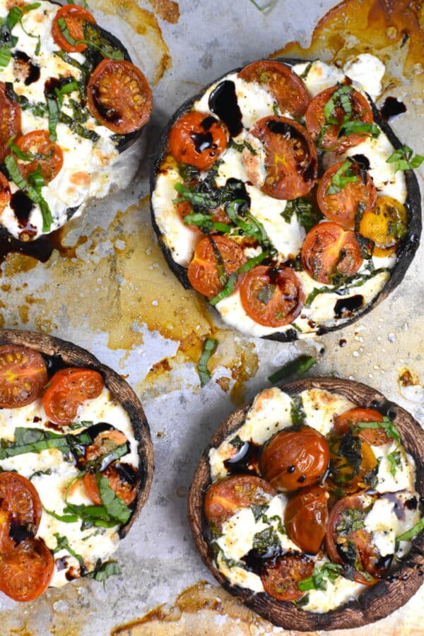 Caprese stuffed portobello mushrooms on a parchment paper.