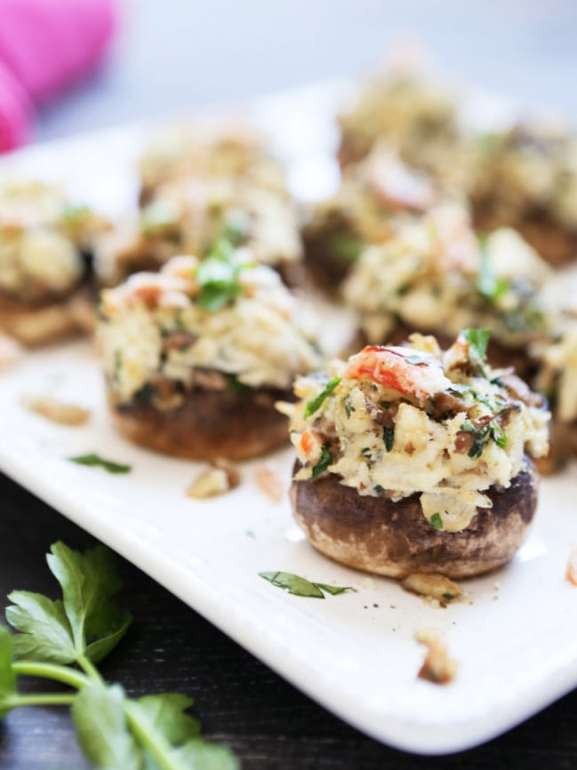 Crab stuffed mushrooms on a white platter.