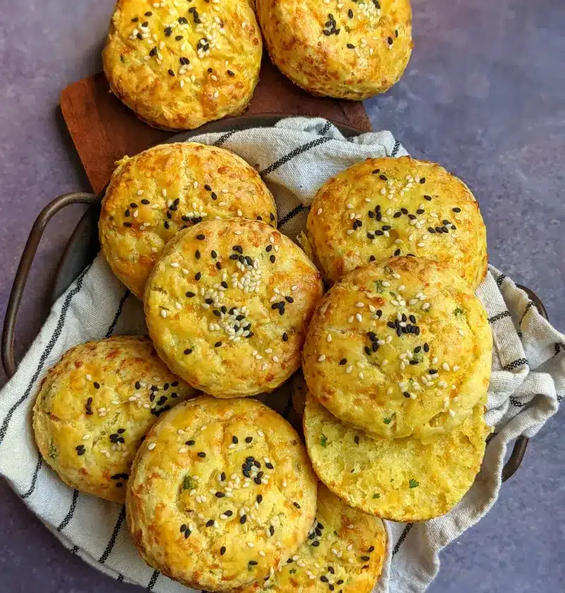 Sesame seed topped masala scones in a cloth lined basket.