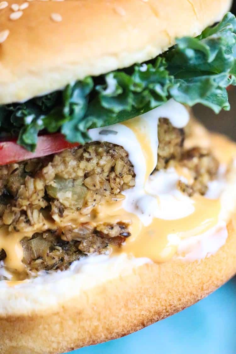 Closeup of smoky mushroom vegan oat burger with lettuce and tomatoes.