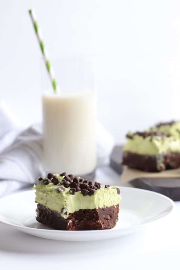 Slice of mint chocolate chip brownie on a saucer.