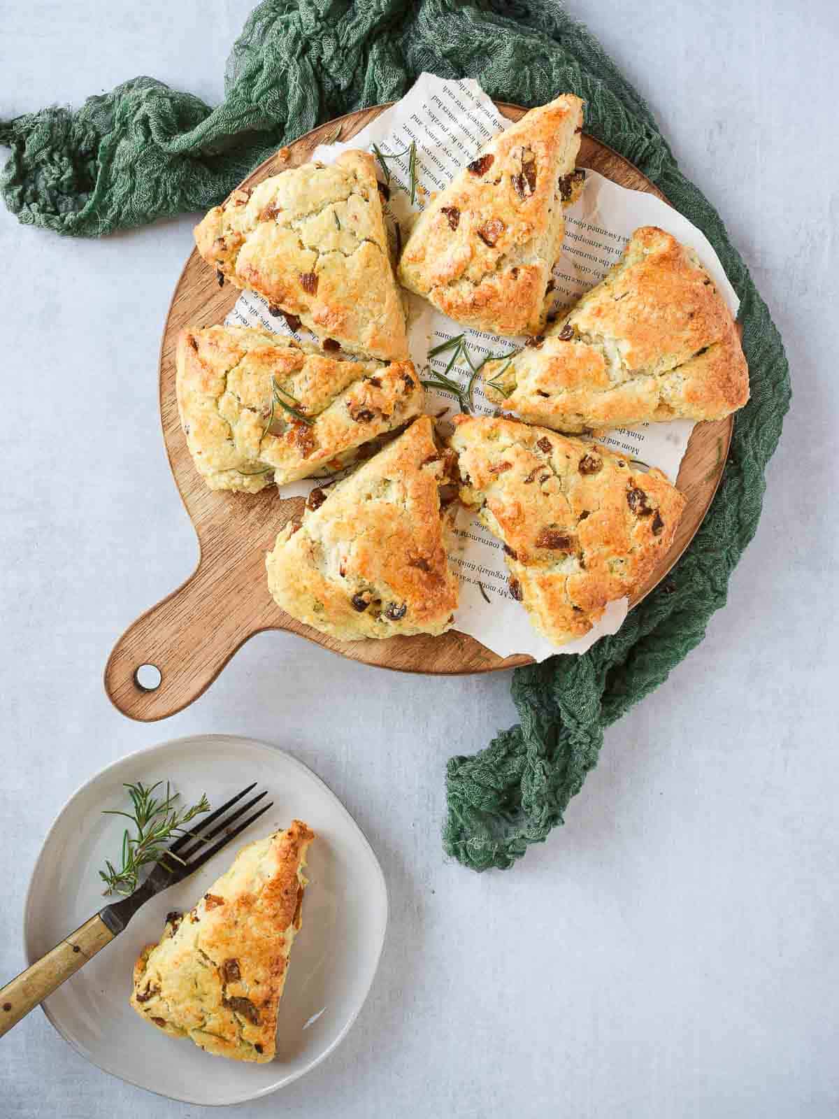 Apricot and rosemary scones on a wooden serving platter.