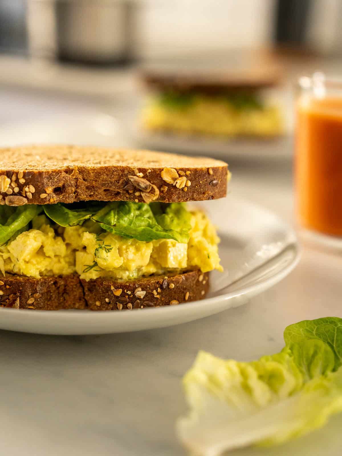 Vegan egg salad sandwich on a white plate.