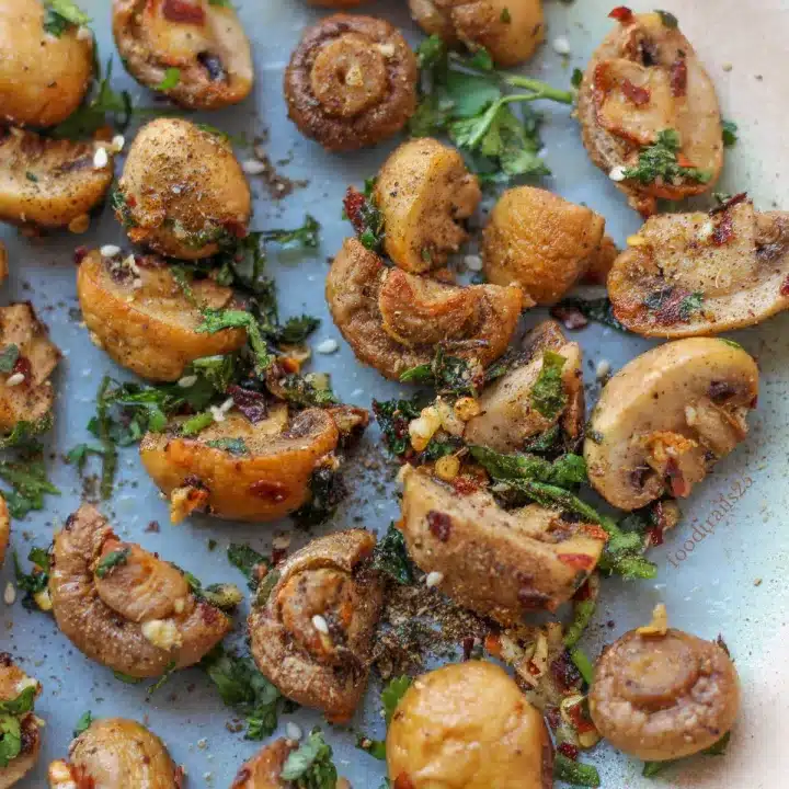 Air fryer garlic butter mushrooms on a blue plates.