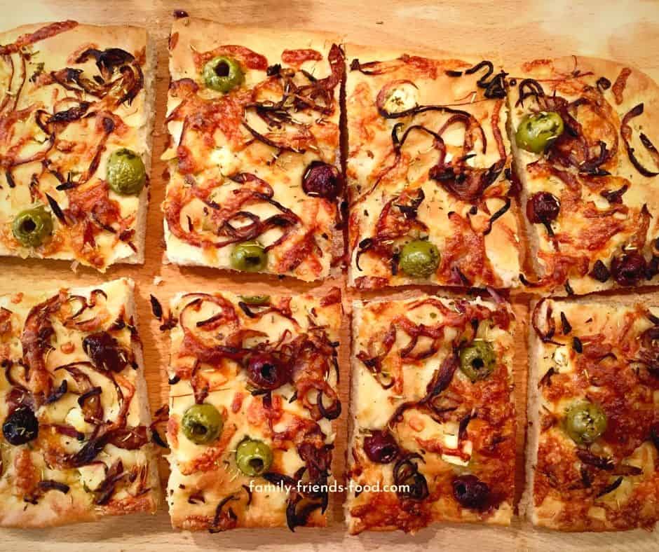 Sliced breakfast focaccia on a wooden cutting board.