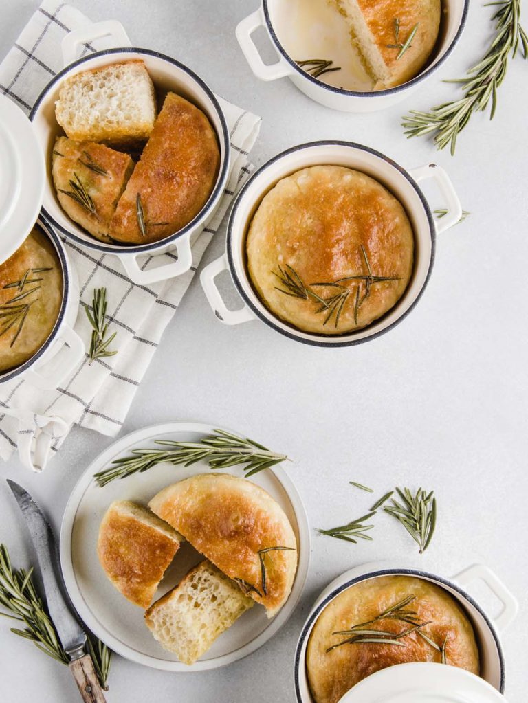 Rosemary focaccia bread in individual baking dishes.