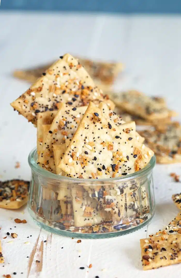 Everything sourdough crackers in a small glass jar.