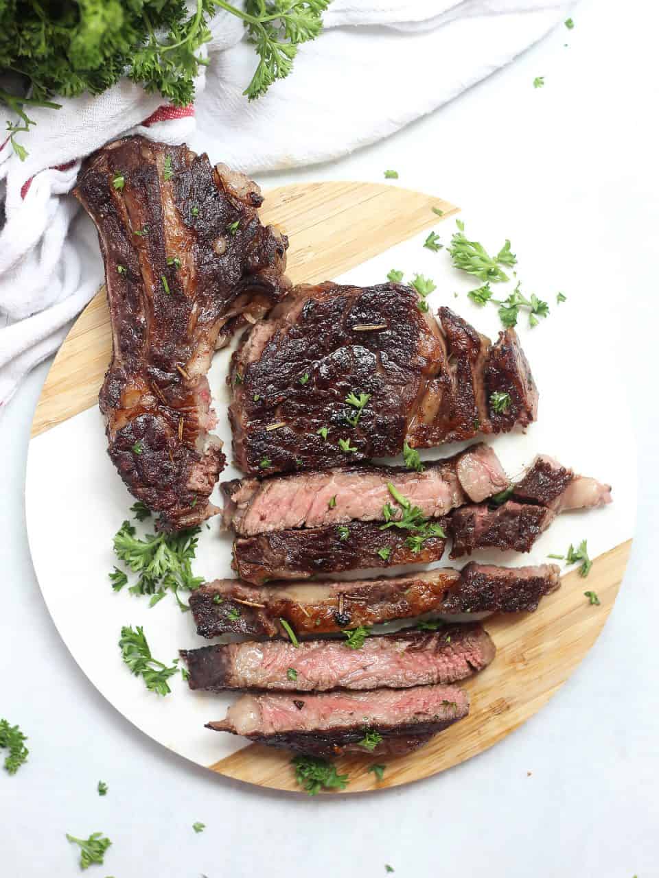 Red wine marinated steak on a round cutting board.