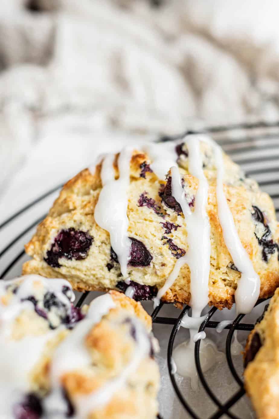 Sourdough scones with blueberries and lemon on a cooling rack.