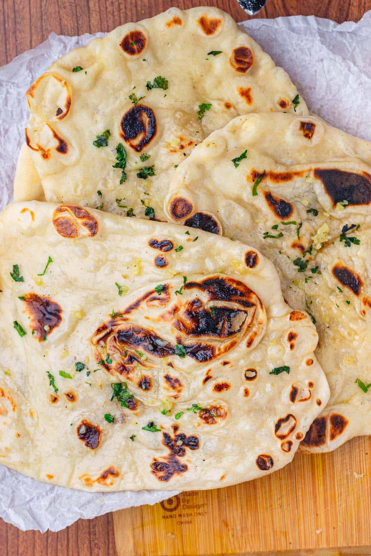 Sourdough discard naan bread on parchement paper.