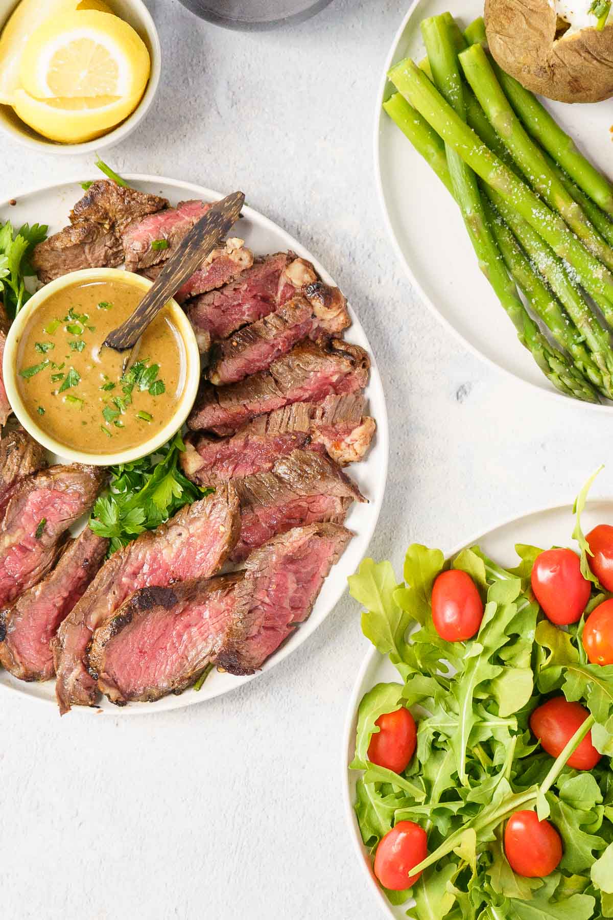 Bavette steak with sauce and an arugula salad with cherry tomatoes.