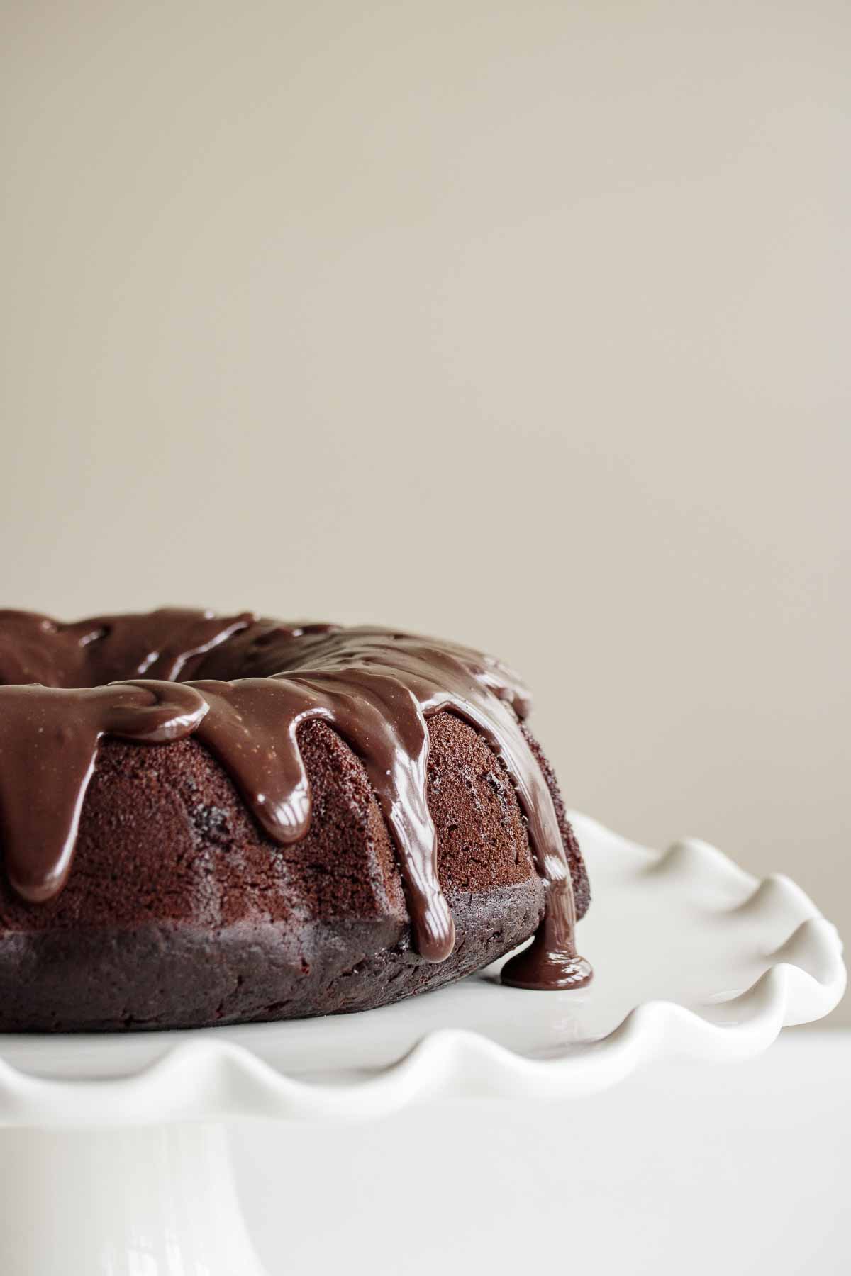 Sourdough chocolate cake on a white cake stand.