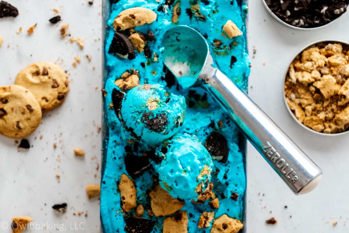 Blue cookie monster ice cream with pieces of chocolate chip and Oreo cookies.