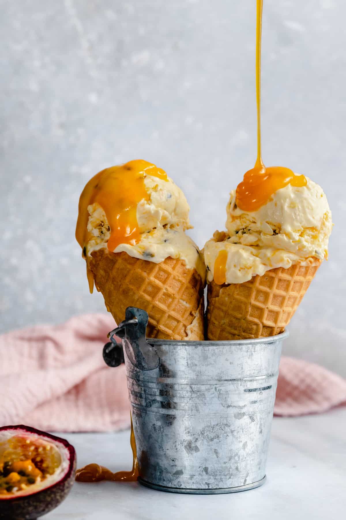 Passion fruit ice cream cones in a silver metal bucket.