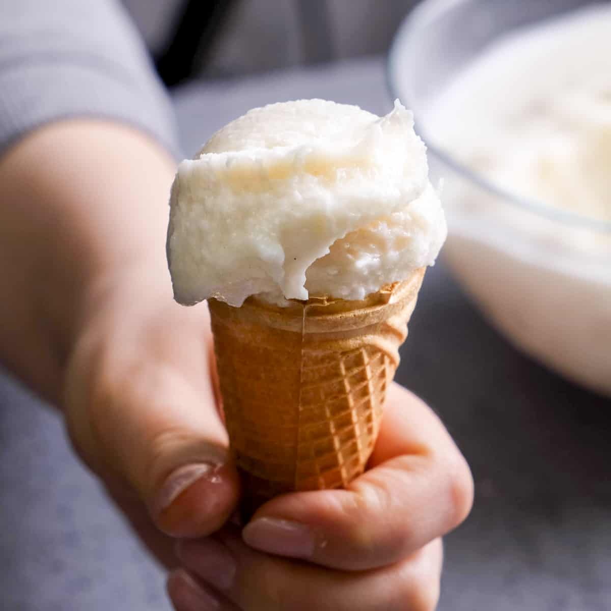 Handing holding a cone with Turkish ice cream.