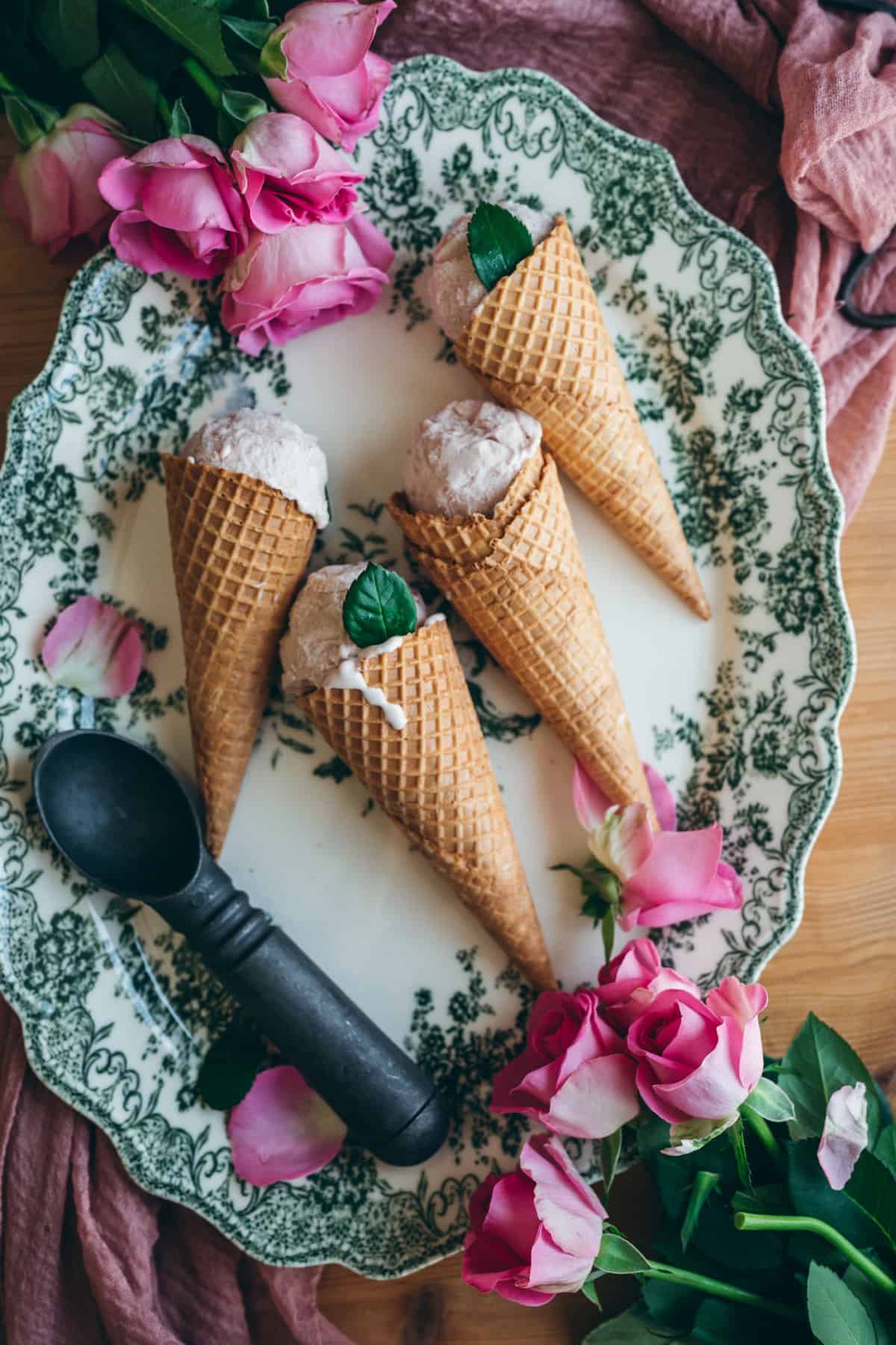 Rose ice cream cones on a decorative plate.