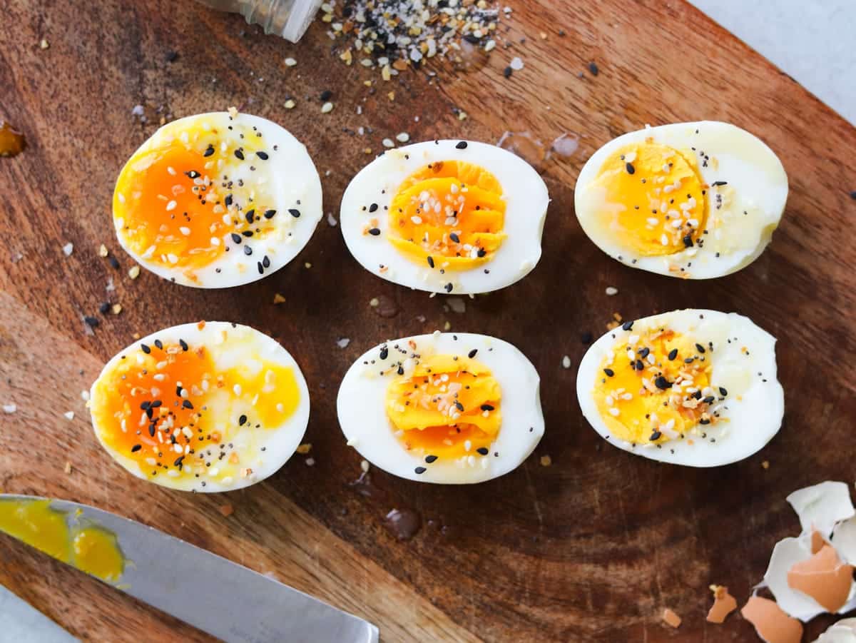 Soft, medium, and hard-boiled eggs on a cutting board.