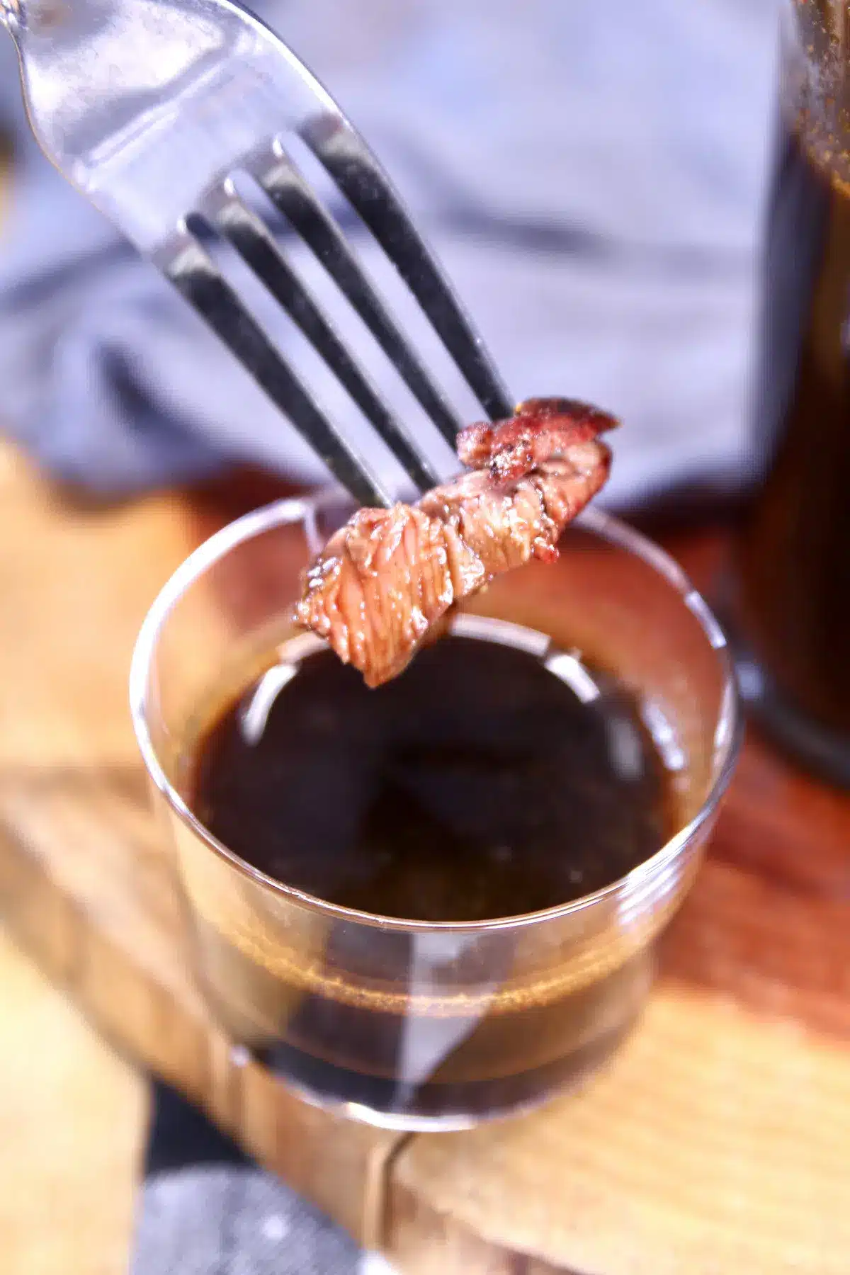 Fork full of steak dipping in homemade steak sauce.