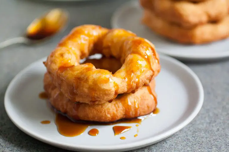 Bolivian donuts on a plate with a drizzle of syrup.