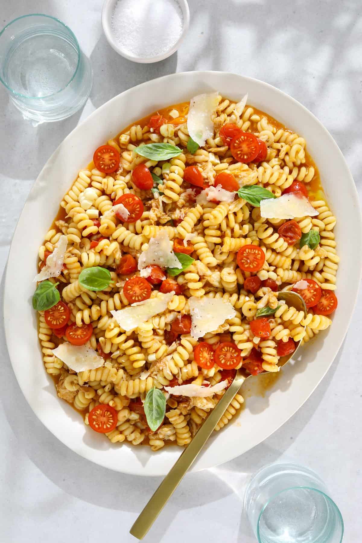 Pasta salad with crab, tomatoes, corn, and basil.